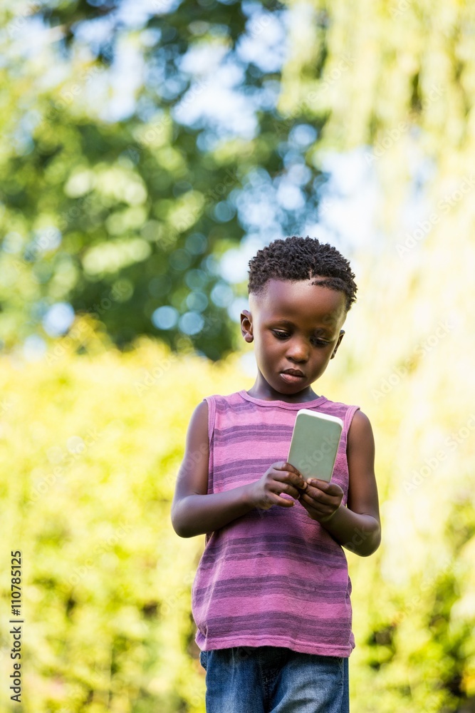 Fototapeta premium Cute mixed-race boy using a smartphone