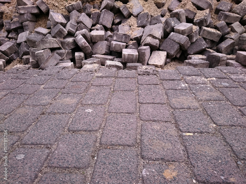 regular brick pattern of the pavement merging into chaotic pattern of bricks thrown together in the distance