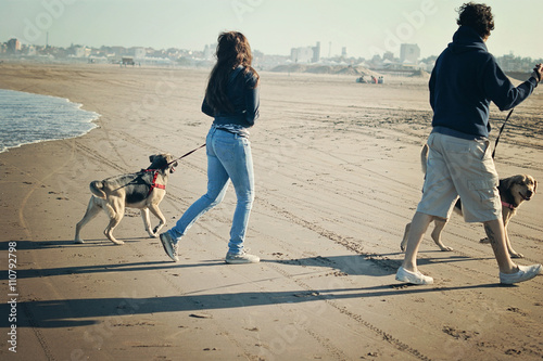 Canvas Print Father and daughter  walking their dogs along the beach in Mar del Plata, Argent