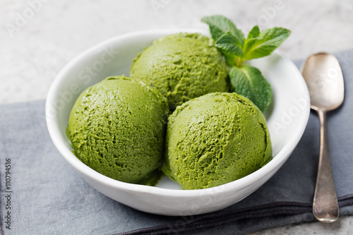 Tablou pe pânză Green tea matcha ice cream scoop in white bowl on a grey stone background