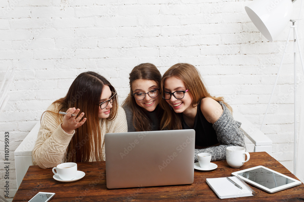 Three young women friends with laptop. 