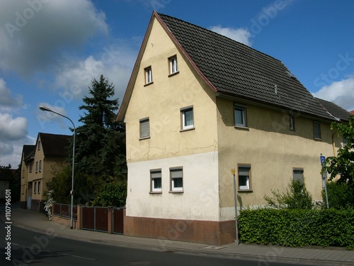 Häuserzeile mit traditionellen Wohnhäusern mit spitzem Giebel in Beige und Naturfarben im Sonnenschein in Heuchelheim bei Gießen an der Lahn in Hessen photo
