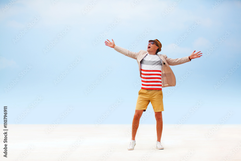 happy fashion man walking around beach. blue sky background. happy fashion man walking around beach. blue sky background.