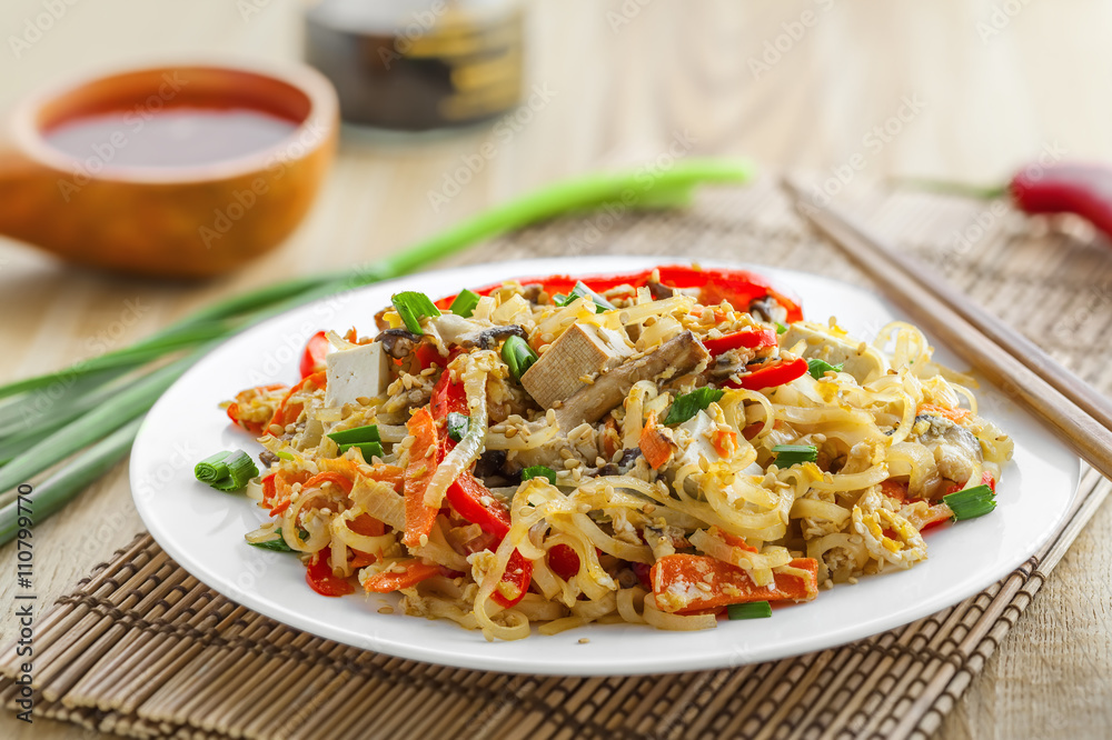 Stirred rice noodles with vegetables, tofu and shiitake mushroom. Traditional Asian food. Stirred rice noodles with vegetables, tofu and shiitake mushroom. Traditional Asian food.