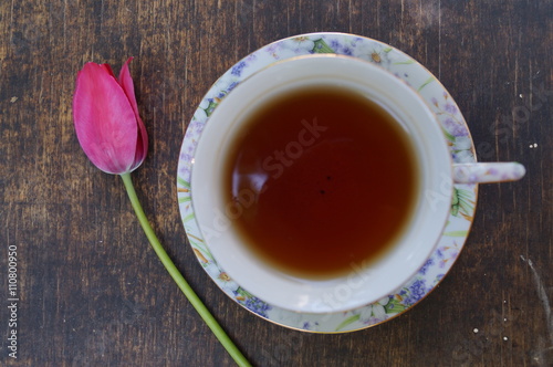 Tea cup, tulip flower, on wooden background