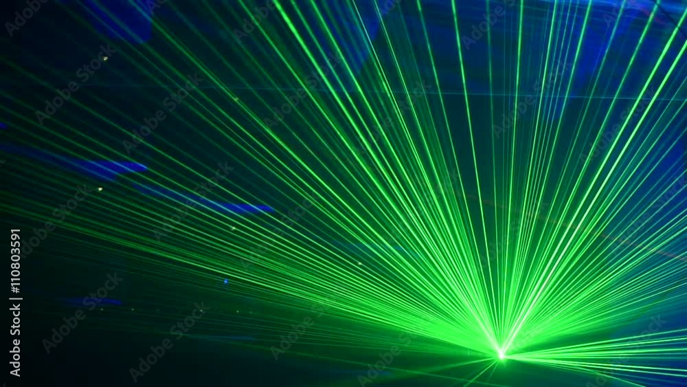 Unrecognizable people watching a beautiful laser show with multicolored lights