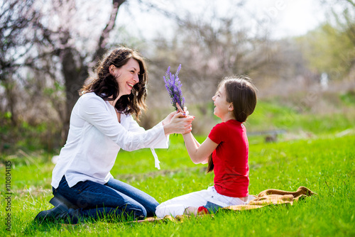 daughter gives her mother flowers on nature
