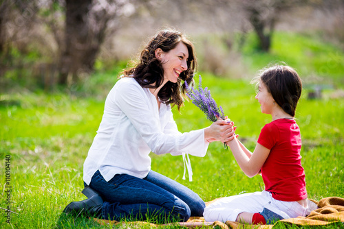 daughter gives her mother flowers on nature © sushytska