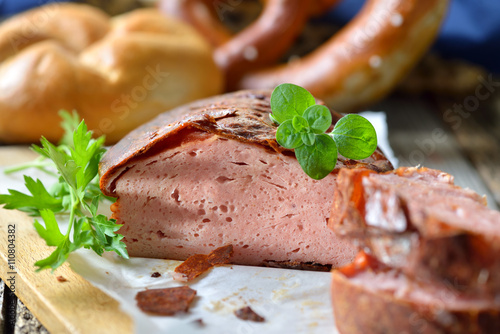 Photos Bayerischer, warmer Leberkäs mit brauner Kruste rustikal serviert, Semmel und Br