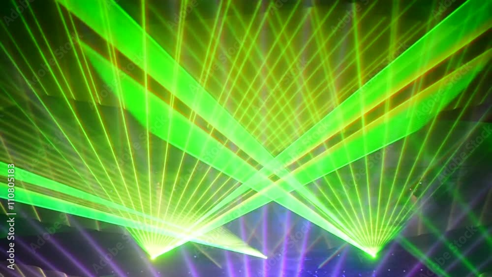 Unrecognizable people watching a beautiful laser show with multicolored lights
