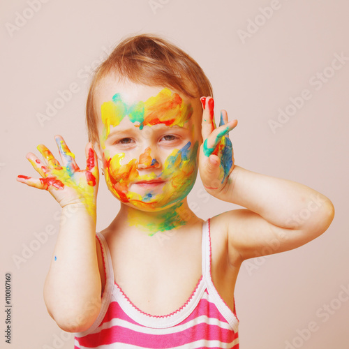 Happy cute little girl with colorful painted hands