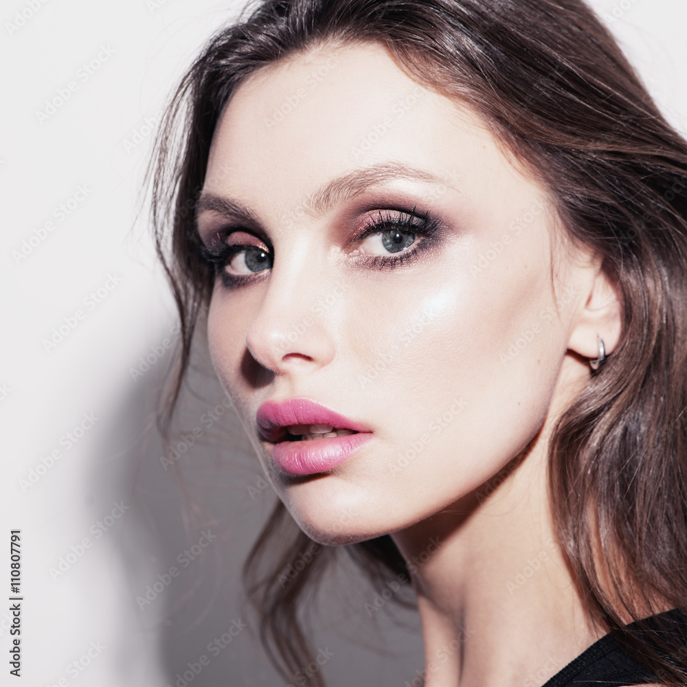 Glamour portrait of beautiful woman. Fashion shiny highlighter on skin, sexy gloss lips makeup and dark eyebrows Glamour portrait of beautiful woman. Fashion shiny highlighter on skin, sexy gloss lips makeup and dark eyebrows