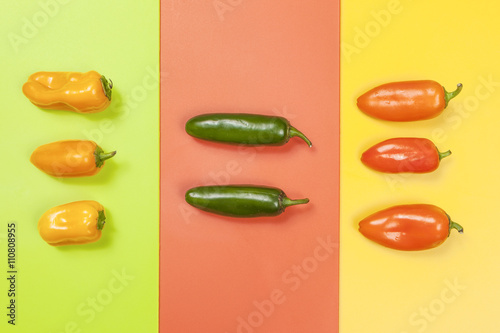 Peppers in color groups on vivid backgrounds.
