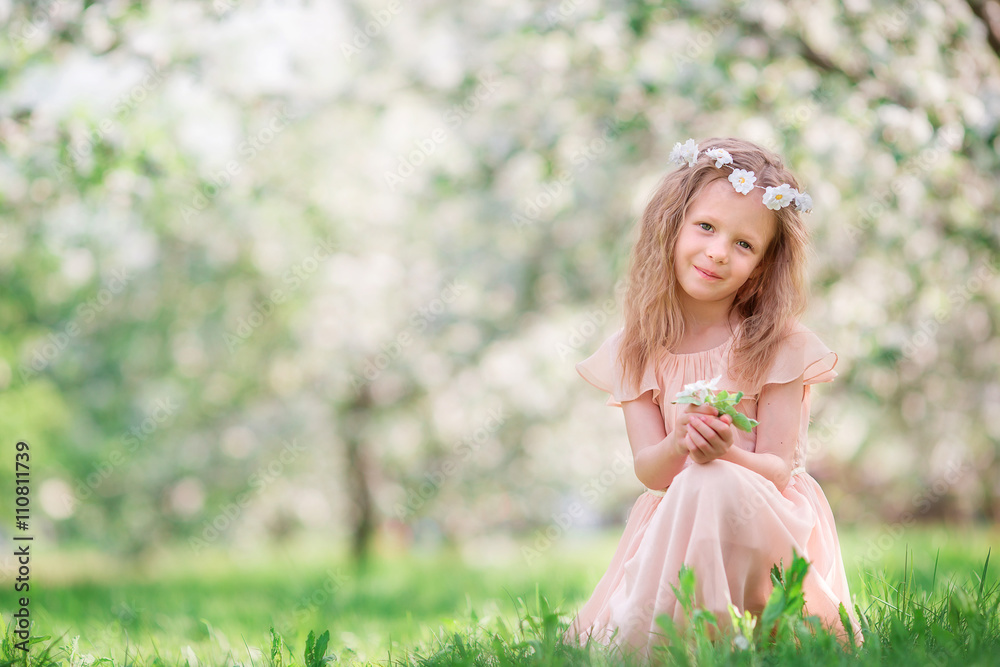 Little girl in blooming cherry tree garden outdoors Little girl in blooming cherry tree garden outdoors