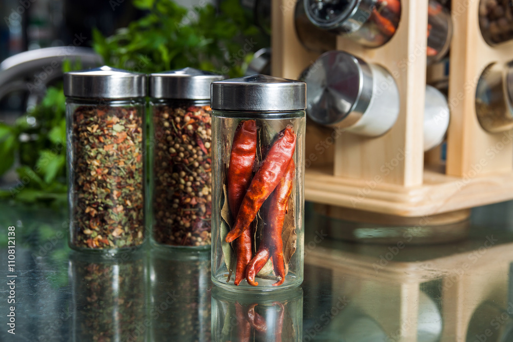 Dried chili pepper in a glass jar and different spices