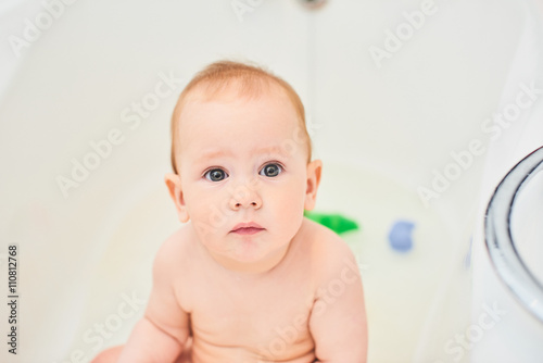 Portrait of smiling one year old boy in a white bathroom