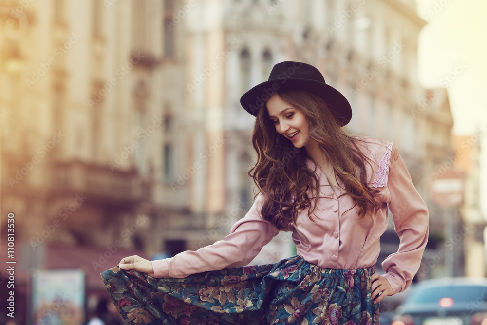 Beautiful young stylish model woman in gray T-shirt and denim jacket posing  near building on the street Stock Photo | Adobe Stock