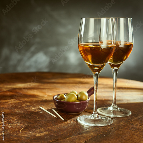 Glasses of Wine on Wooden Table with Green Olives