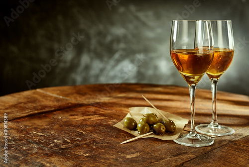 Two Glasses of Wine and Olives on Wooden Table