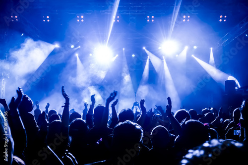 silhouettes of concert crowd in front of bright stage lights