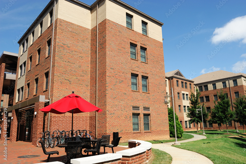 apartment building in community with outdoor table and sun umbrella