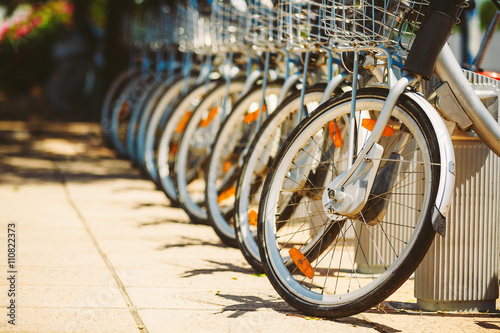 Row of parked vintage bicycles bikes for rent on sidewalk. © Grigory Bruev
