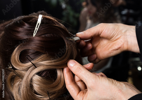 Master stylist makes the bride wedding styling. beautiful satisfied client in professional hairdressing salon