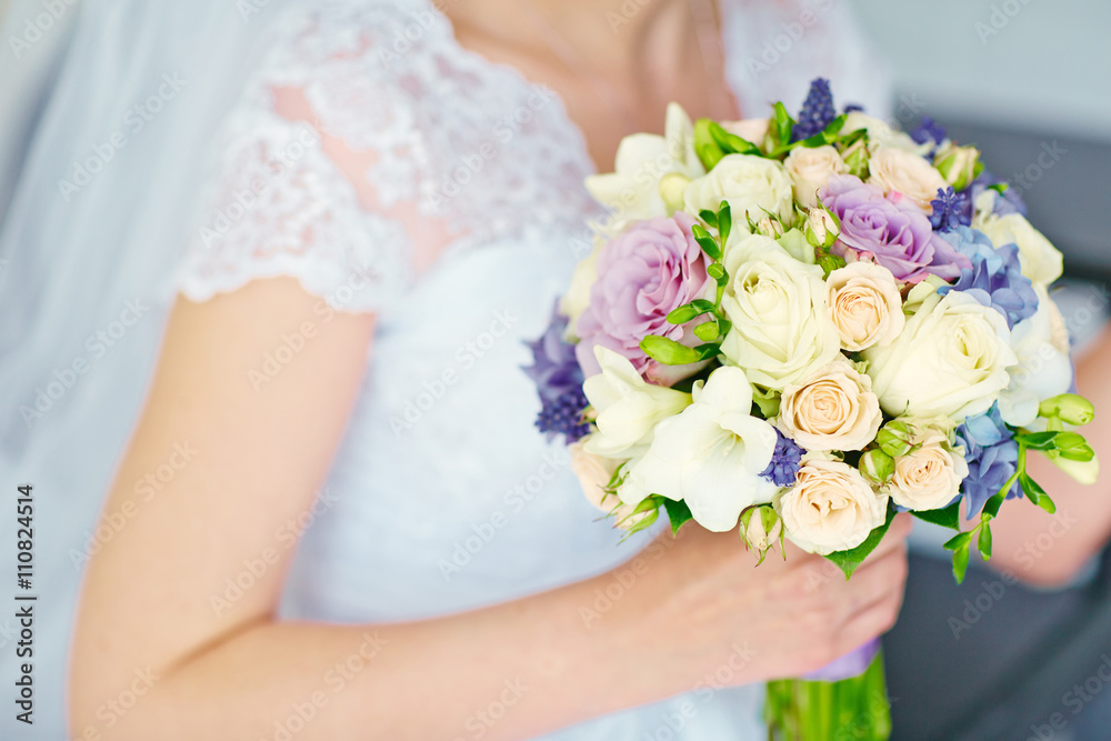 Beautiful wedding bouquet of flowers in hands of the bride.