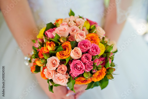    Beautiful wedding bouquet of flowers in hands of the bride.