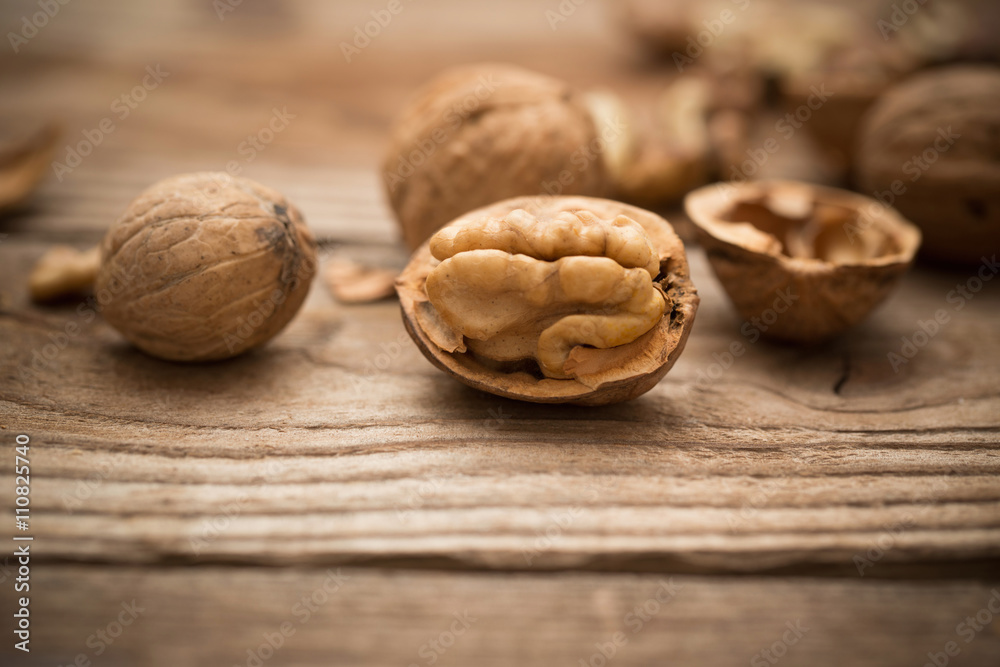 Walnut kernels and whole walnuts on rustic old wooden table Walnut kernels and whole walnuts on rustic old wooden table