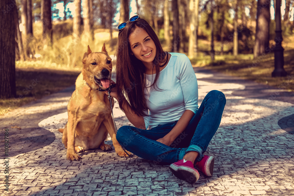 Attractive brunette female posing with her dog.