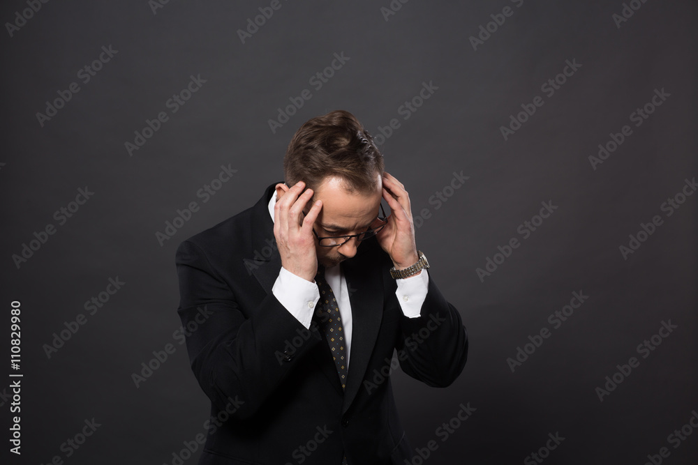 Businessman having headache after hard-working day in office. Studio shot of astonished and sad man in studio. Businessman having headache after hard-working day in office. Studio shot of astonished and sad man in studio.