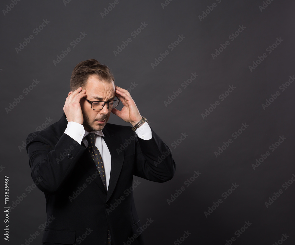 Portrait of handsome businessman concentrating on business projects in studio. Young man in black suit meditating with his eyes closed. Portrait of handsome businessman concentrating on business projects in studio. Young man in black suit meditating with his eyes closed.