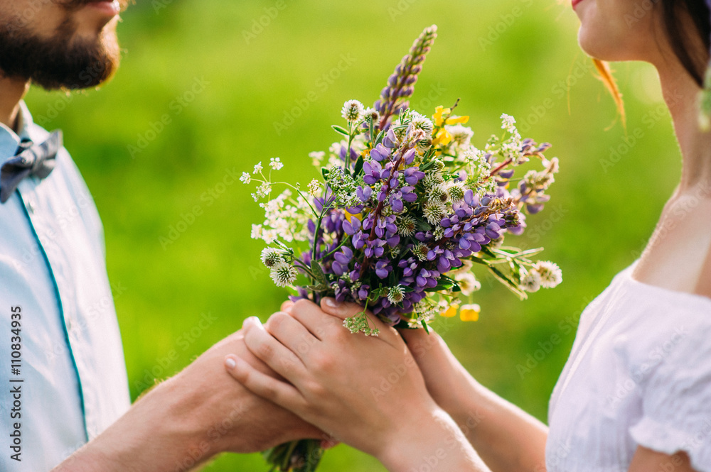 Fototapeta premium Romantic guy gives a girl a rustic bouquet