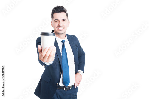 Joyful young salesman in suit giving a cup of coffee