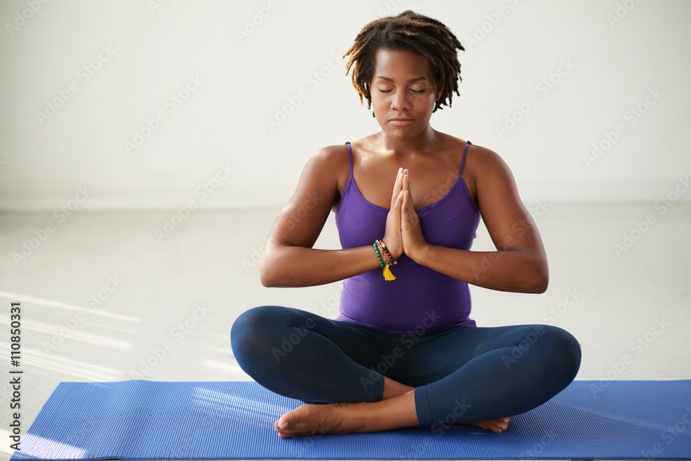 Young African-American woman meditating in lotus position Young African-American woman meditating in lotus position