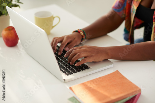 Close-up image of woman typing on laptop