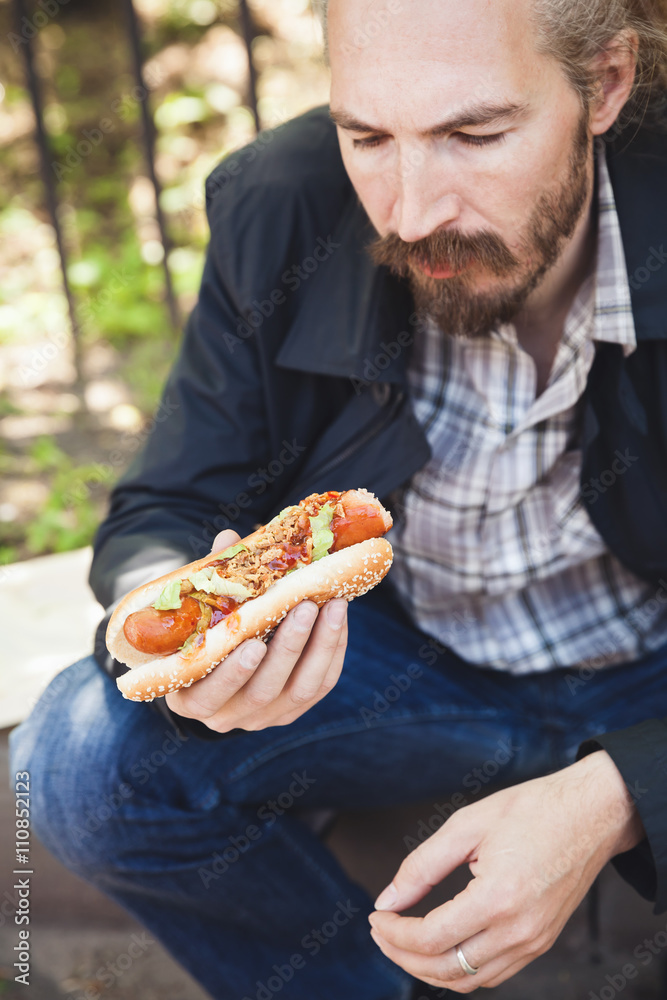 Bearded Asian man eating hot dog in summer Bearded Asian man eating hot dog in summer