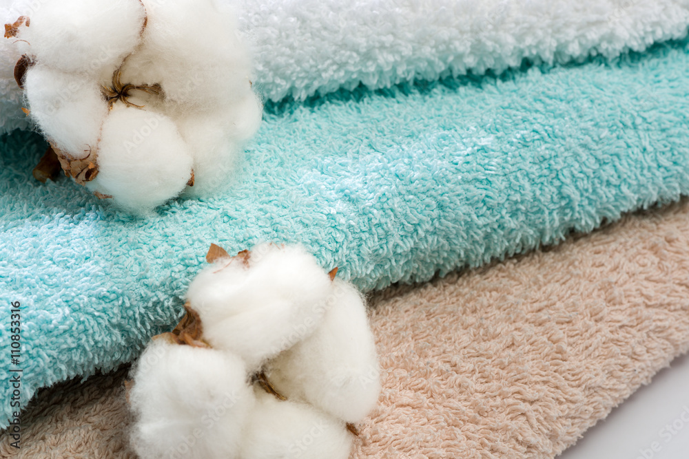 Stack of bath towels with cotton blossom Stack of bath towels with cotton blossom