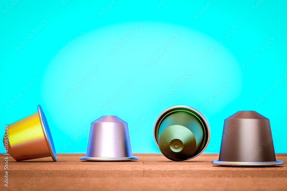 Coffee capsule multicolored on a table near a blue wall Coffee capsule multicolored on a table near a blue wall