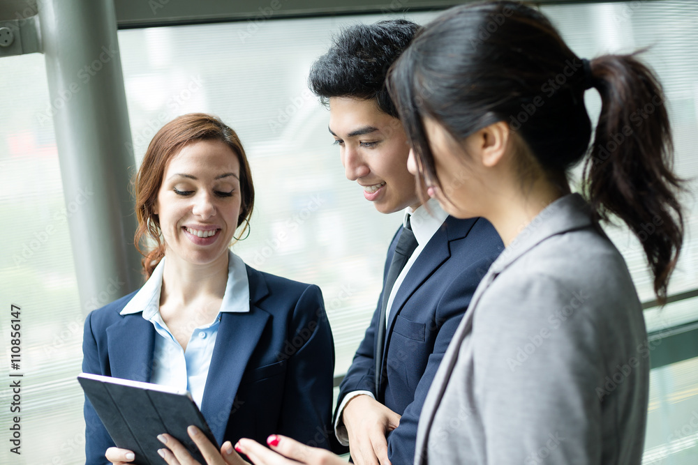 Business team discuss something on tablet computer Business team discuss something on tablet computer