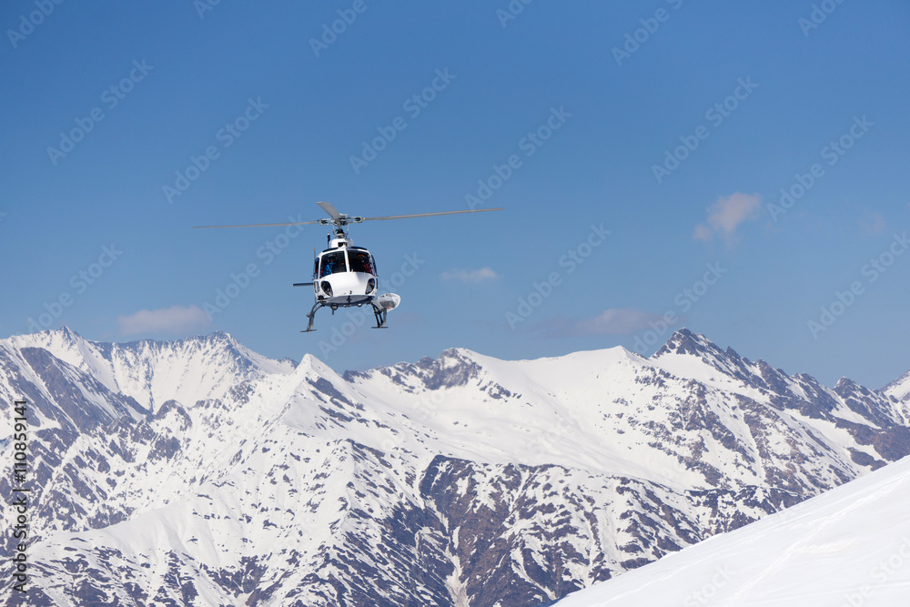 White rescue helicopter in the mountains White rescue helicopter in the mountains