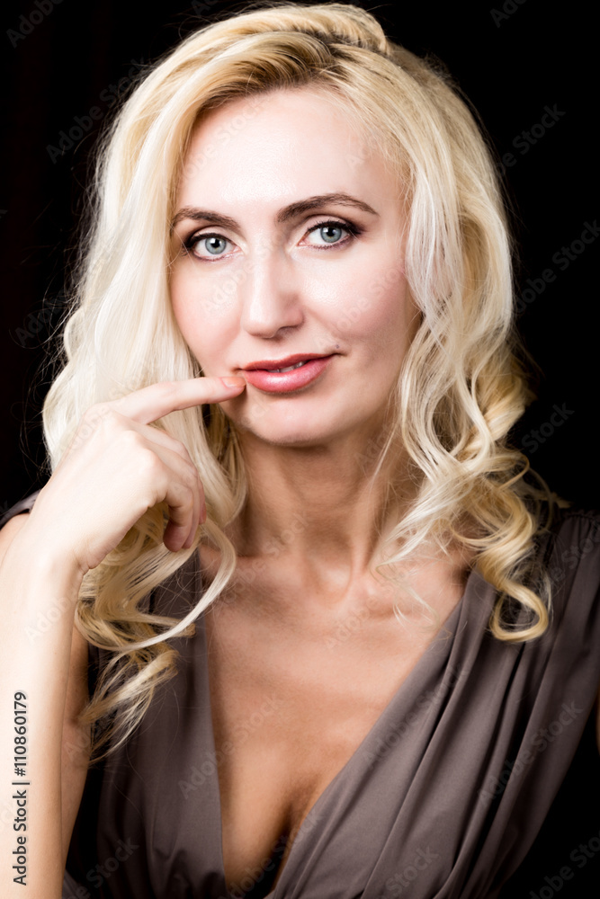 Close up of red lips of seductive blonde girl raising finger to her mouth. Let it be our secret Close up of red lips of seductive blonde girl raising finger to her mouth. Let it be our secret