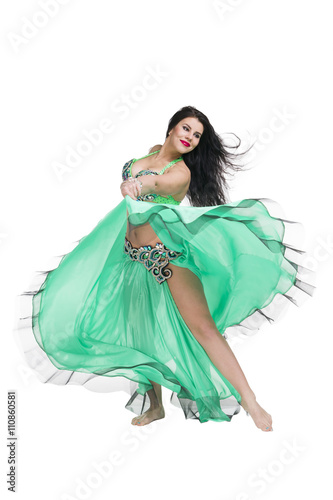 Young beautiful exotic eastern women performs belly dance in ethnic green dress. Isolated on white background