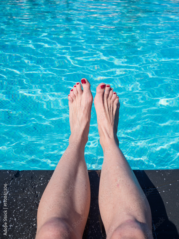Woman feet at the swimming pool