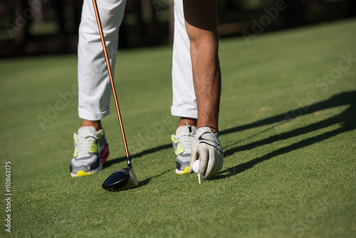 golf player placing ball on tee