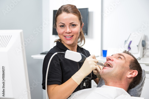 Dentist scanning patient's teeth with CEREC scanner