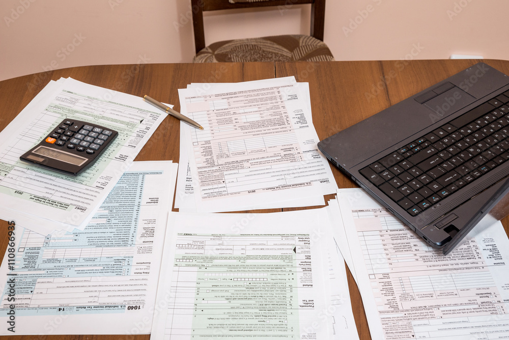 Fototapeta premium many 1040 US Individual Tax Form with laptop on table