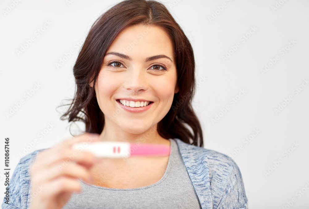 happy smiling woman holding home pregnancy test happy smiling woman holding home pregnancy test