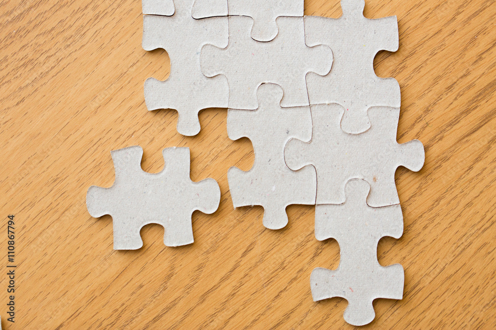 close up of puzzle pieces on wooden surface close up of puzzle pieces on wooden surface
